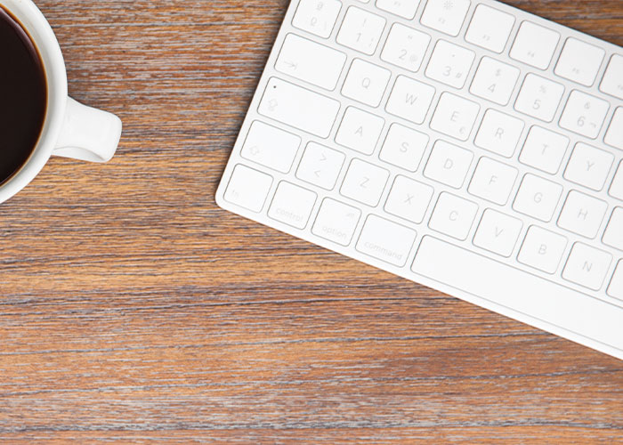 Picture of keyboard and coffee cup from above.